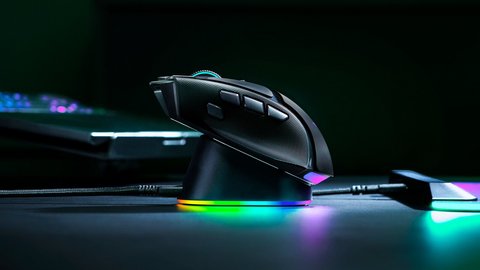 Razer Basilisk V4 Pro colocado sobre la base de carga Razer Mouse Dock V2 Pro con iluminación RGB