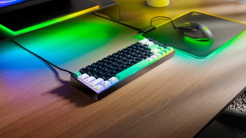 El teclado sobre un escritorio con la iluminación RGB encendida, junto a un ratón y una alfombrilla Razer