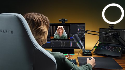 Una streamer frente a la Razer Kiyo V2 Pro montada sobre el monitor