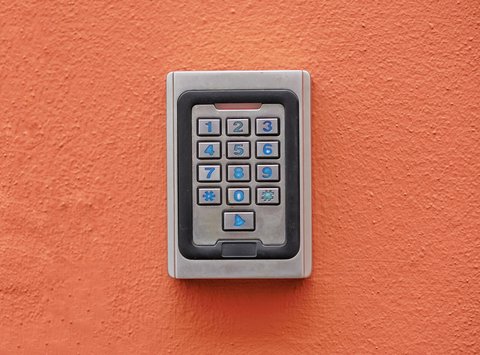Teclado numérico de un sistema de alarma instalado en una pared exterior naranja