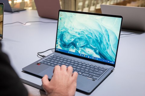 Una mano usando el teclado y el touchpad de un ASUS Zenbook 14 azul